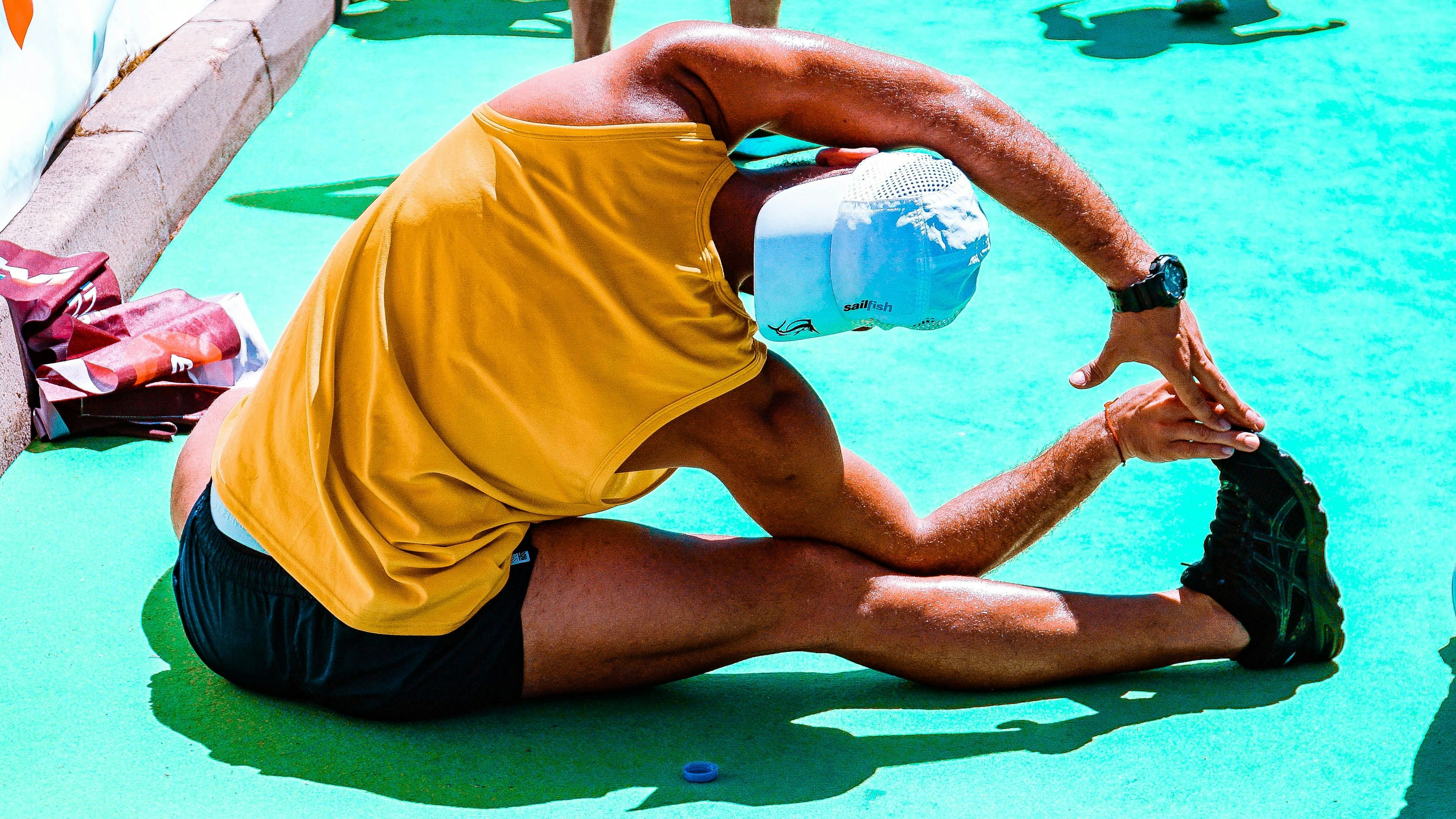 A runner performs a sitting stretch in athletic clothes
